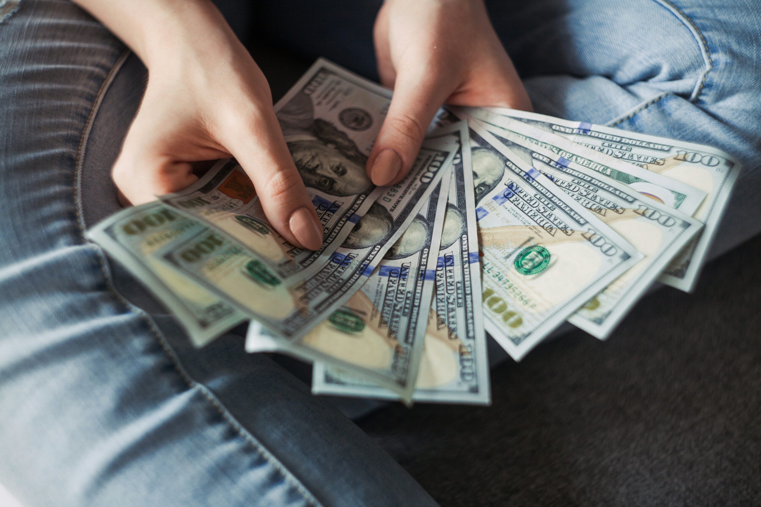 Person holding cash, symbolizing financial decisions